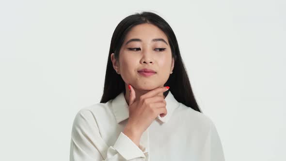 Close-up view of a positive asian korean woman pondering about something