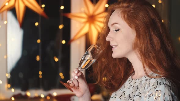 Ginger Haired Smiling Woman with a Glass of Champagne Celebrating New Year