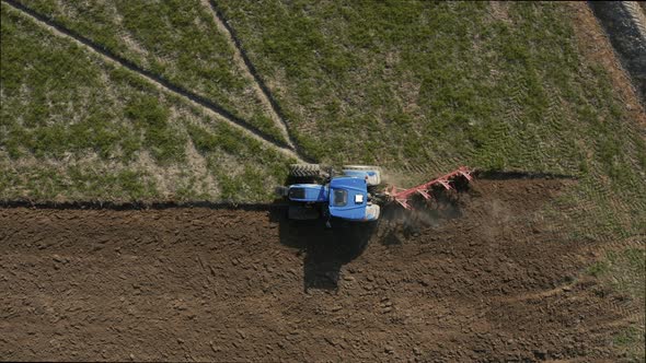 Aerial view of a tractor plowing a field in Lomellina, Po Valley, Italy.