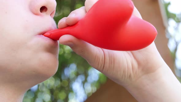 Teenager Boy is Blowing Air Balloon