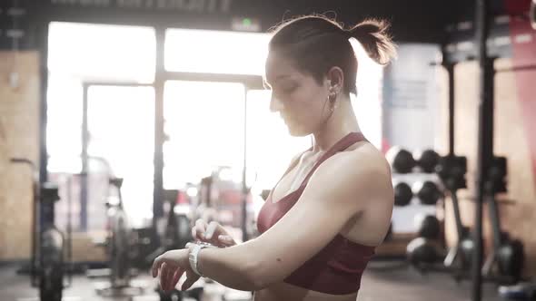 Female Athlete Using Fitness Smart Watch to Check Results Tracker After Workout