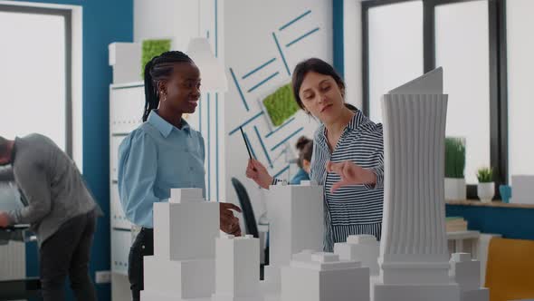 Architects Giving Highfive and Celebrating Urban Project Progress with Building Model