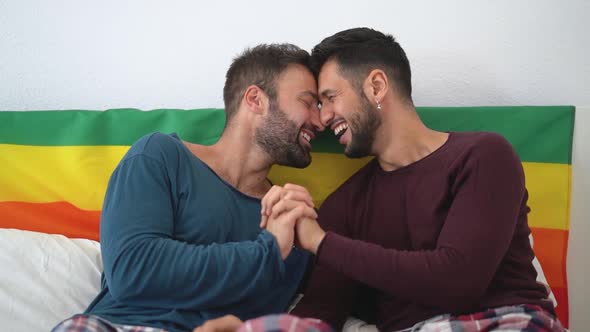 Happy gay couple having romantic moments in bedroom