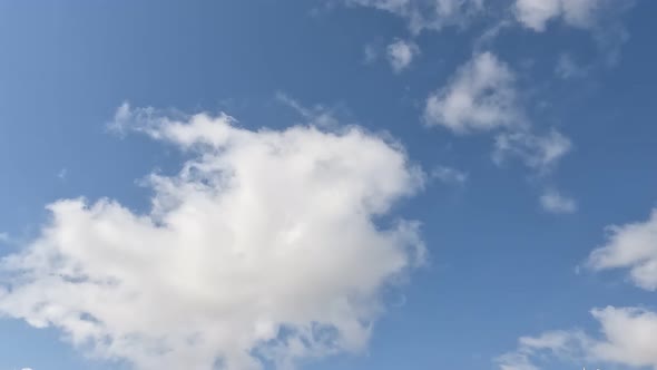 White Clouds Flying On Blue Sky With Sun Rays