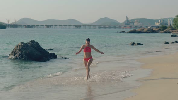 Graceful Girl in Bikini Runs Turning Around on Surf Line