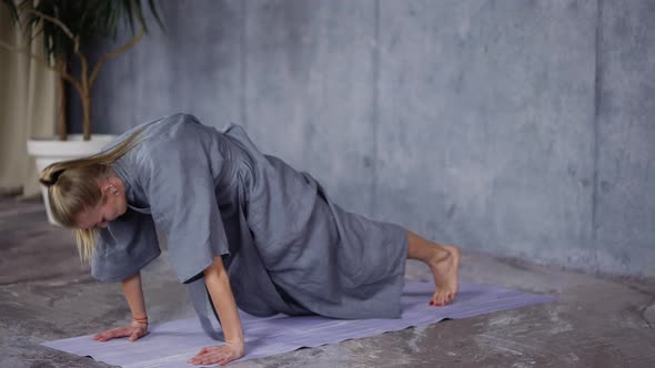 Blonde Woman in Stylish Robe Doing Yoga on Mat