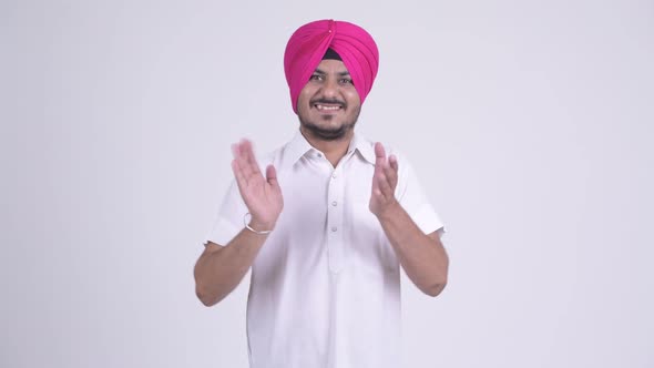 Happy Bearded Indian Sikh Man Wearing Turban and Clapping Hands
