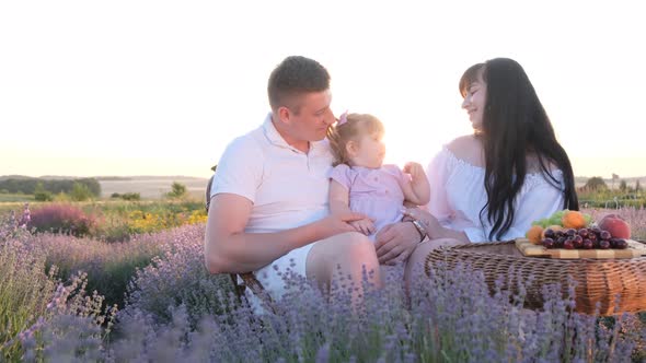 Happy Family on a Picnic Near a Lavender Field Having a Fun Weekend Outdoors