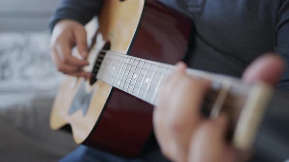 Rack Focus Close Up of Man Playing an Acoustic Guitar