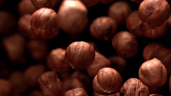 Super Slow Motion Shot of Hazelnuts Flies After Being Exploded Against Black Background 1000Fps