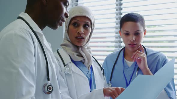 Close-up of Multi-Ethnic doctors discussing over medical report in hospital