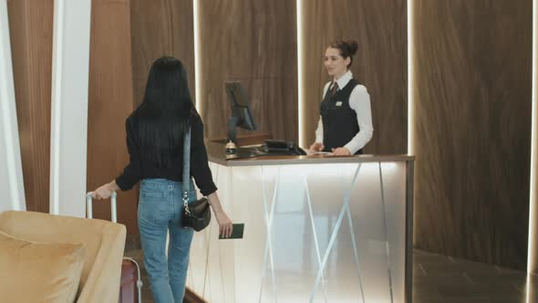 Woman Checking In at Hotel