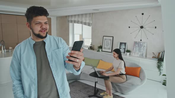 Latin Man Video Calling On Smartphone At Home
