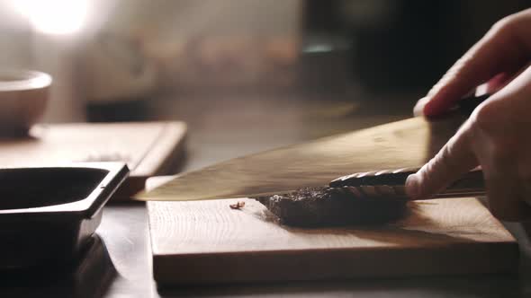 Restaurant Cooking  Chef Cutting a Piece of Meat with a Knife on the Board