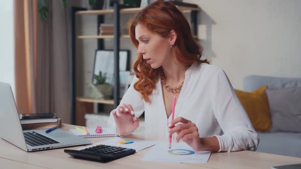 Caucasian Woman Deals with Business Analytics Sits at Desk with Laptop