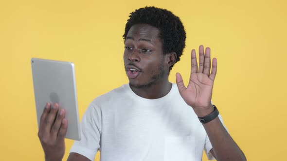 Video Chat By African Man Via Tablet Yellow Background