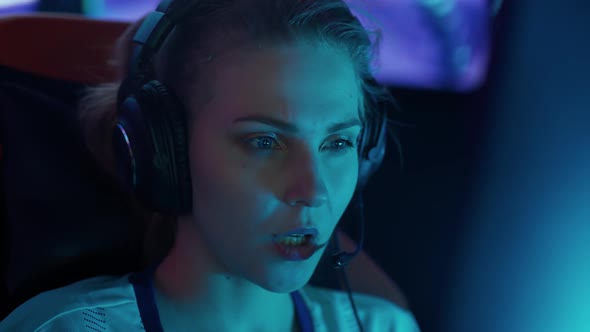 Portrait of a Young Female Gamer in Headphones Plays a Video Game Cyber Sportsman at the Game