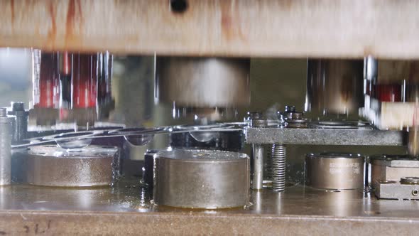 Close up of a punch press forming metal parts in a production line