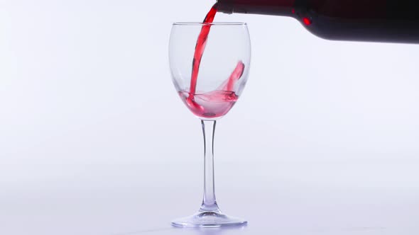 Concept of Food and Drinks Red or Pink Wine Poured Into a Glass on a White Background