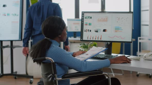 African Woman with Disabilities in Wheelchair Working on Computer