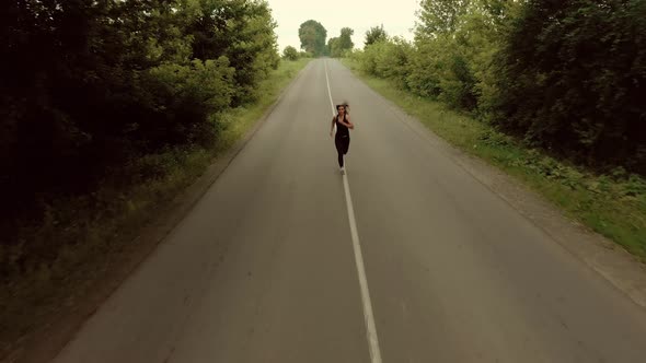 Aerial View Young Woman in Sportswear Run Fast Along Asphalt Road