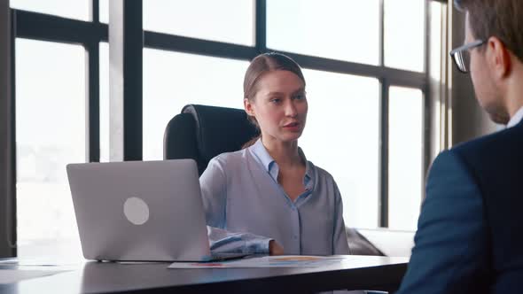 Young businesswoman hiring new colleague shaking hands after successful job interview