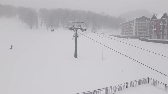 Flying over rope-way with gondolas at mountain resort Crystal Park in Bakuriani. Snowy winter day.