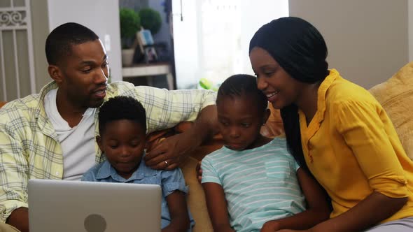 Family using laptop in living room 4k