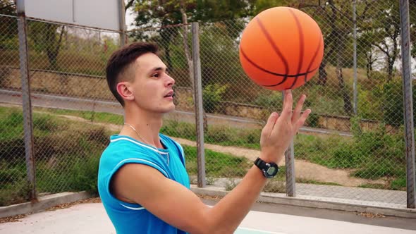 Portrait of a Young Serious Looking Basketball Player Spinning a Basketball on the Street Playing