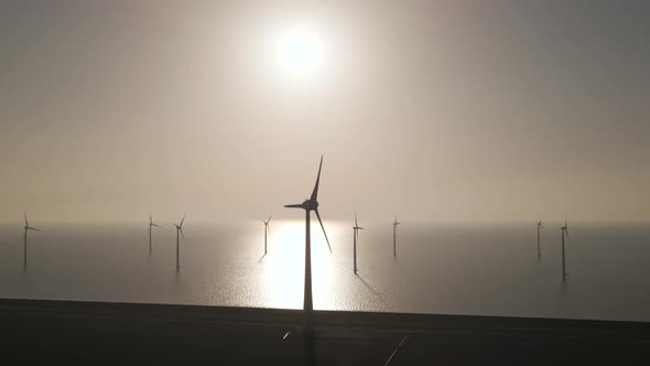 Aerial towards Wind turbines spinning on Epic Windpark on Sea with bright sunlight, Renewable Enery
