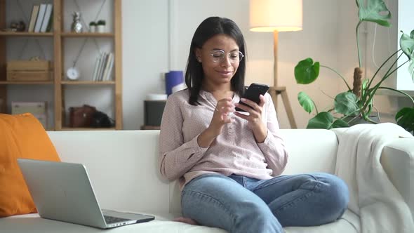 Woman Type Text on Mobile Phone and Sit on Sofa in Living Room Spbd