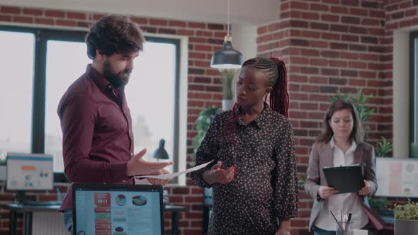 Pregnant Adult and Colleague Giving Highfive After Finishing Business Project