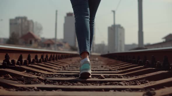 Girl Walks To Home On Railroad Tracks After Canceled Tram Public Transport. Woman Feet In Jeans.