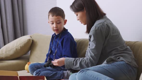 Handsome Asian mother and son playing a game and talking