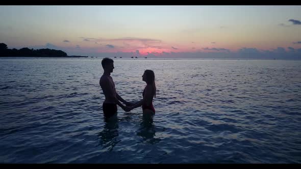 Teenage lovers tan on relaxing sea view beach trip by aqua blue ocean with bright sand background of