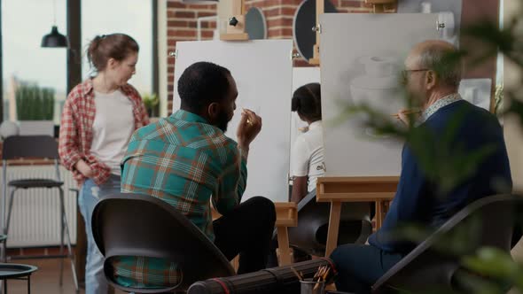 Team of Young Man and Elder Person Attending Art School Class