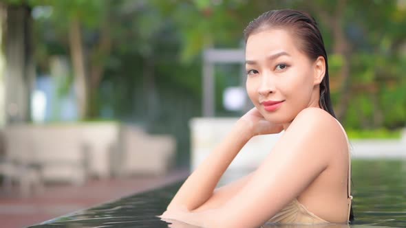 Young asian woman enjoy around outdoor swimming pool for leisure