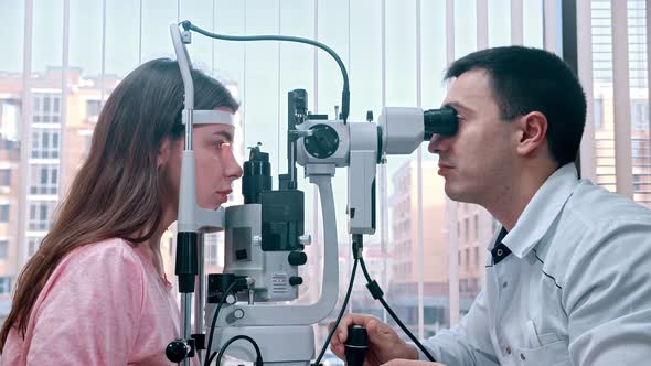 Doctor Checking Young Woman's Visual Acuity with a Special Equipment