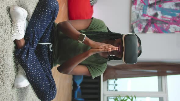 Vertical Portrait of Afro Woman in Vr Headset Meditating in Lotus Pose at Home