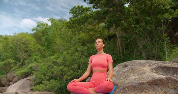 Meditating Woman She Dressed in Pink Sportswear Her Eyes are Closed She is Relaxed Outdoors