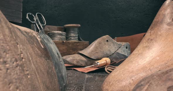 Cobbler workplace with tools, shoes and laces.