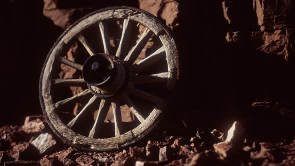 Old Wooden Cart Wheel on Stone Rocks