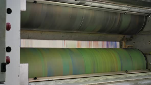 Ink rollers at high speed in a printing factory printing newspapers