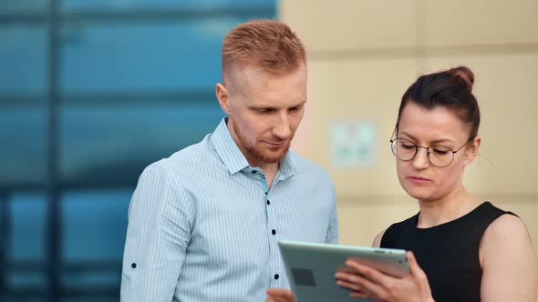 Enthusiastic Colleague Talking Looking at Screen of Tablet Pc Outdoor Medium Closeup