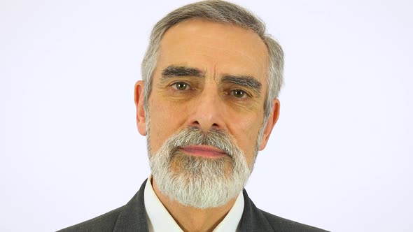 An Elderly Man Looks Seriously at the Camera - Face Closeup - White Screen Studio