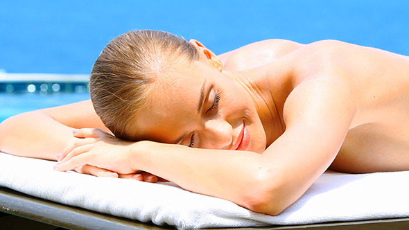 Beautiful Blonde Girl Taking Sun Bath on Poolside