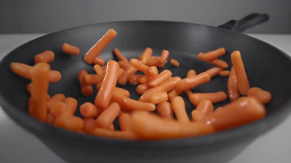 Small Carrots Are Falling in Slow Motion To the Pan, Fresh Vegetables Are Falling