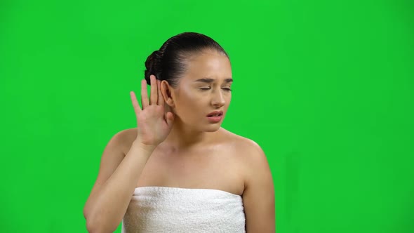 Woman in White Towel Does Not Hear Anything, Shows His Hands Emotions Isolated on Green Screen at