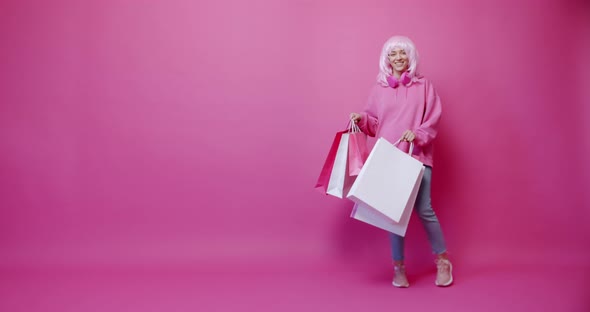 Happy Girl Enjoys After Shopping with Colorful Bags in Pink Colour Concept