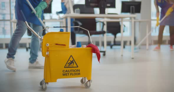 Cropped Shot of Janitors with Mop Cleaning Modern Office Floor